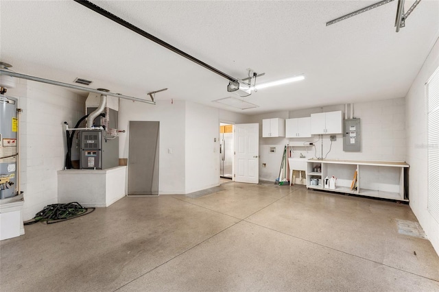 garage with electric panel, a garage door opener, and water heater