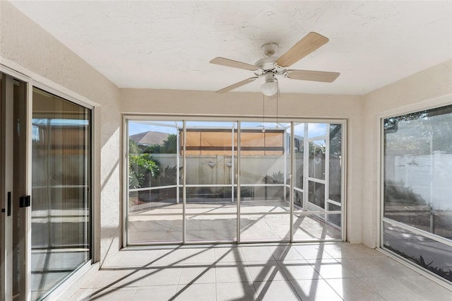 unfurnished sunroom with ceiling fan