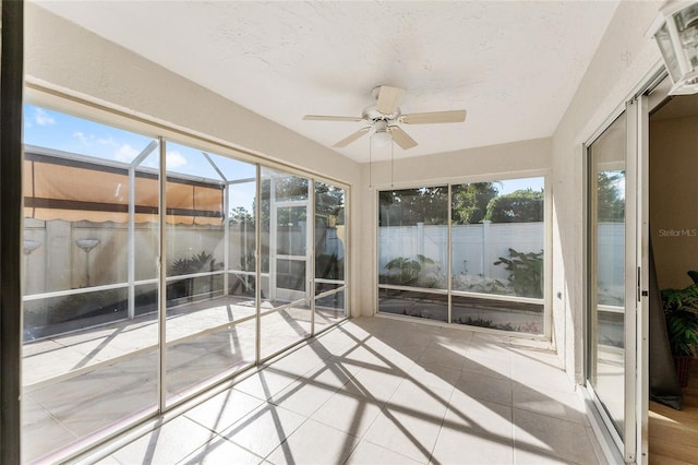 unfurnished sunroom featuring ceiling fan