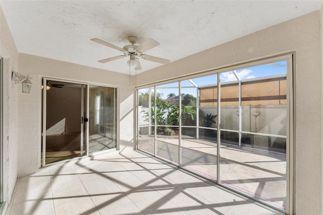 unfurnished sunroom with ceiling fan