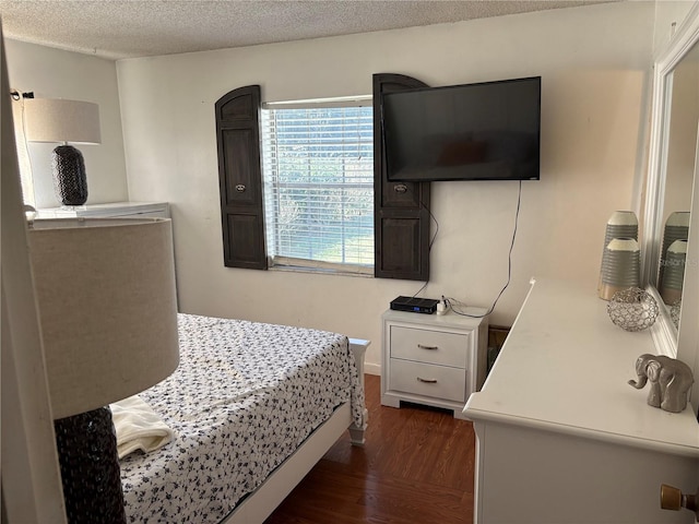 bedroom with a textured ceiling and dark hardwood / wood-style floors