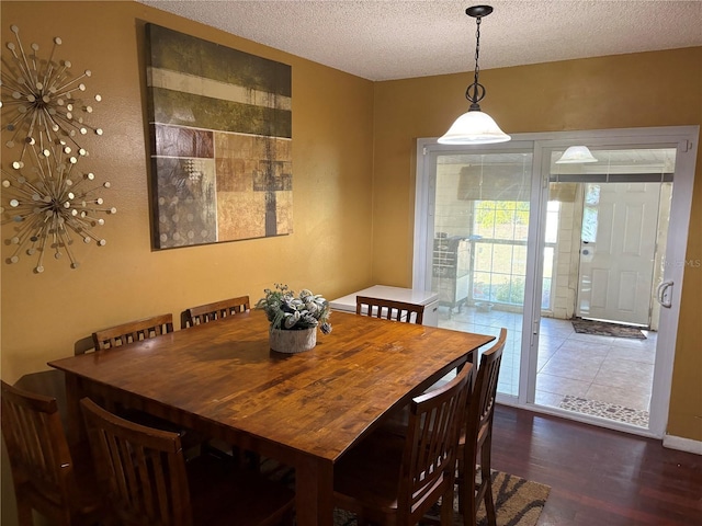 dining space featuring a textured ceiling and dark hardwood / wood-style floors