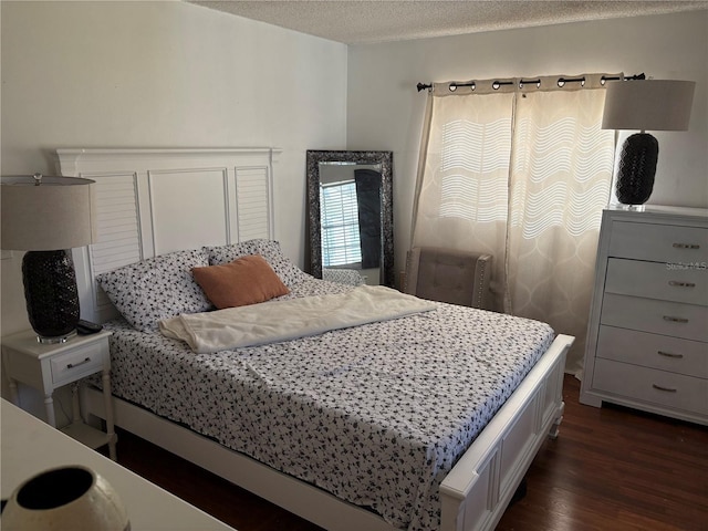 bedroom featuring a textured ceiling and dark hardwood / wood-style floors