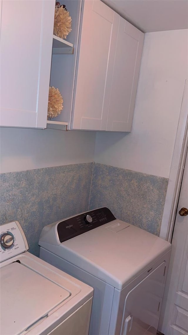 washroom with cabinets and washing machine and clothes dryer