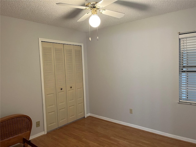 bedroom with ceiling fan, a closet, hardwood / wood-style floors, and a textured ceiling