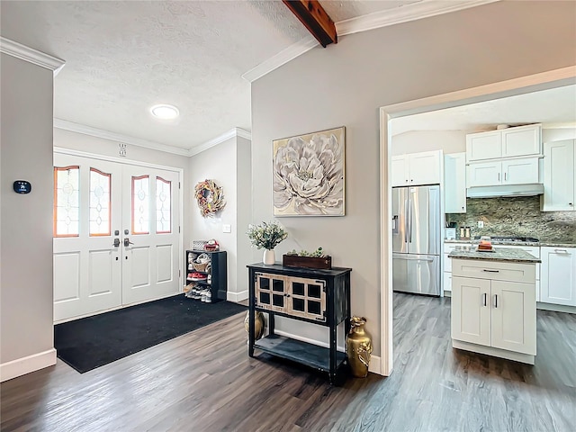 foyer featuring french doors, ornamental molding, a textured ceiling, dark wood-type flooring, and lofted ceiling