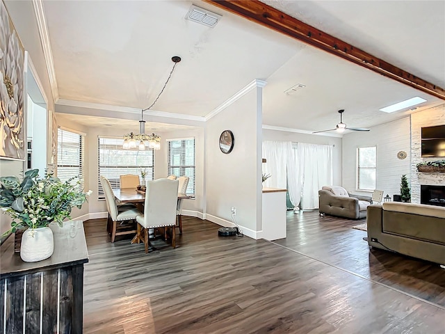 dining space with dark hardwood / wood-style floors, a fireplace, a healthy amount of sunlight, and ceiling fan with notable chandelier