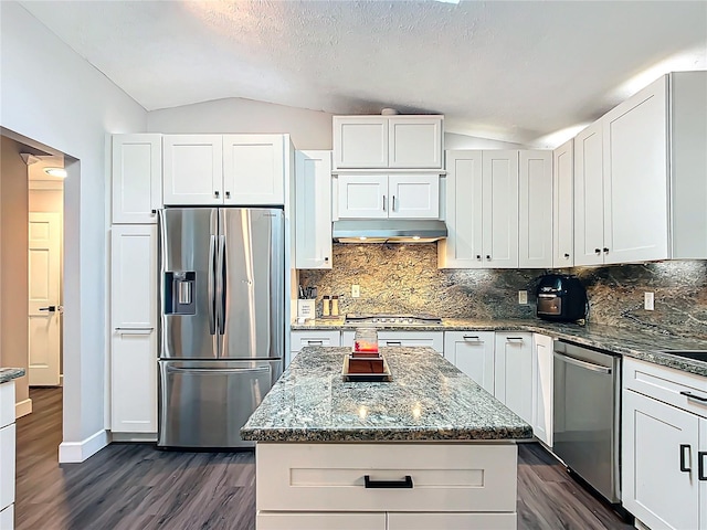 kitchen with white cabinetry, a center island, stainless steel appliances, and vaulted ceiling