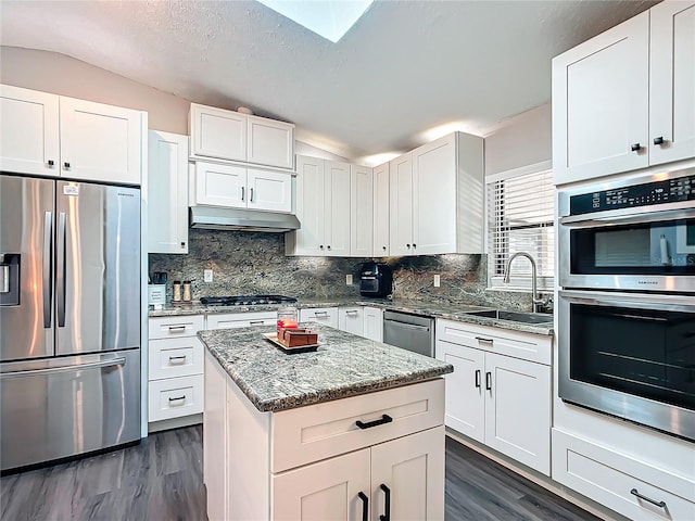 kitchen featuring sink, white cabinets, lofted ceiling, and appliances with stainless steel finishes