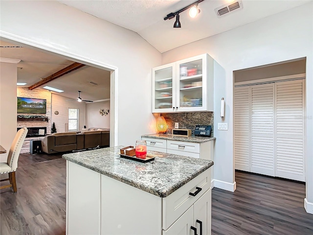 kitchen featuring white cabinets, lofted ceiling with beams, ceiling fan, and light stone counters