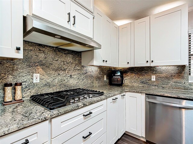 kitchen featuring backsplash, stainless steel appliances, white cabinetry, and stone countertops