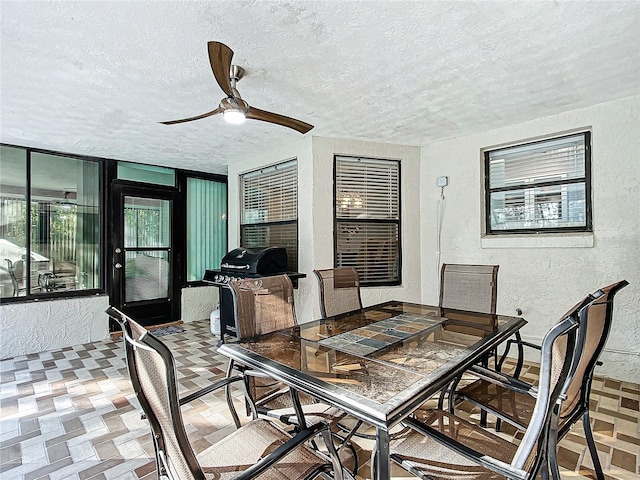 dining space with a textured ceiling and ceiling fan