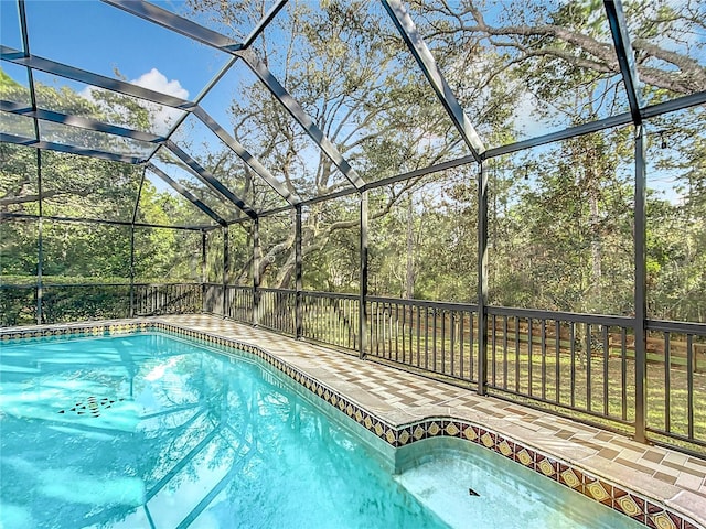 view of pool with a patio and glass enclosure