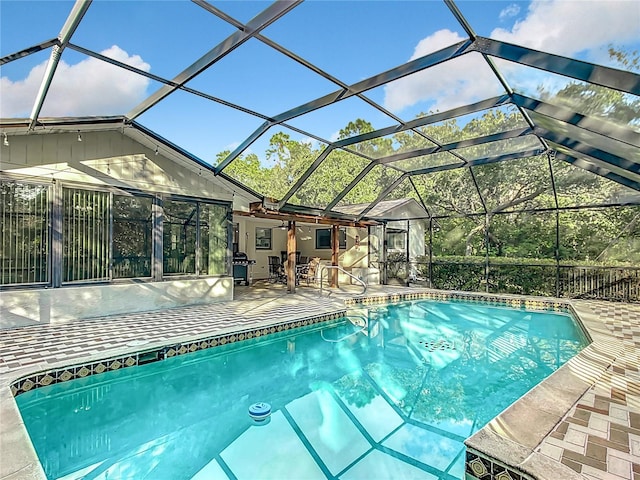 view of swimming pool featuring a patio area, ceiling fan, and a lanai