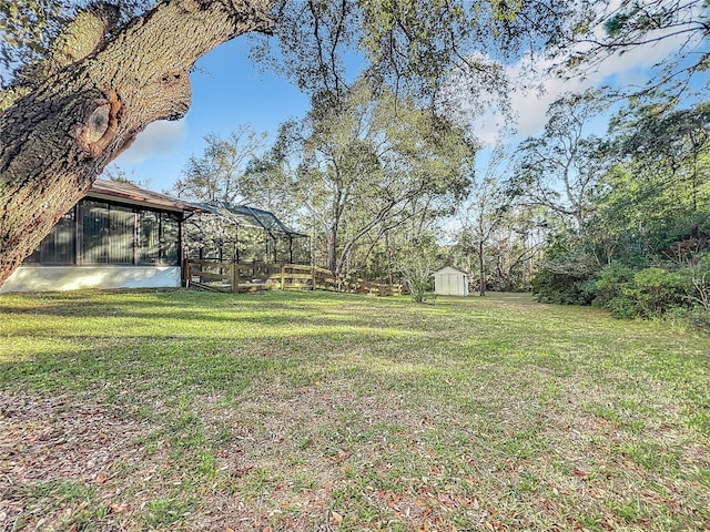 view of yard featuring a sunroom and a storage shed