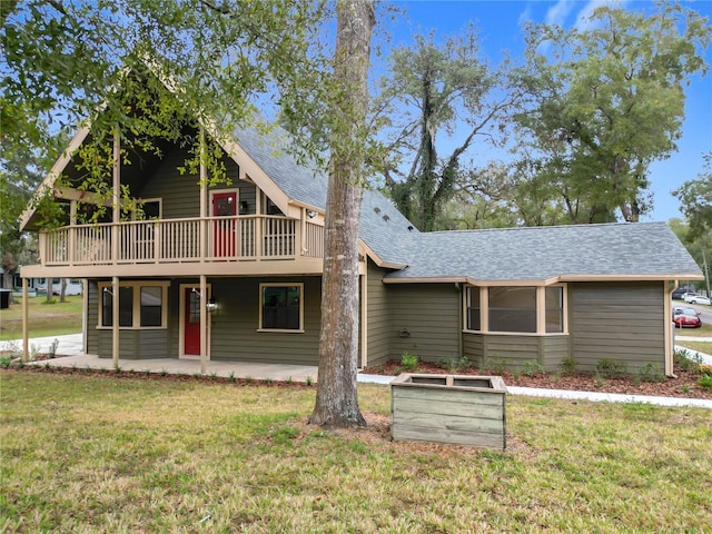 view of front of house with a wooden deck, a patio, and a front yard