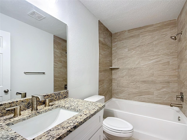 full bathroom with vanity, a textured ceiling, toilet, and tiled shower / bath