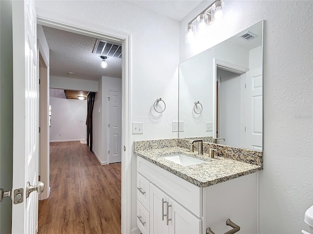 bathroom featuring vanity, a textured ceiling, and hardwood / wood-style flooring