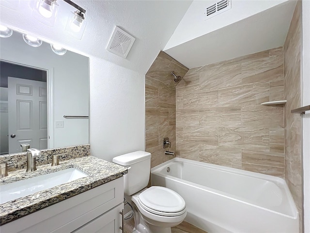 full bathroom featuring vanity, tiled shower / bath combo, and toilet