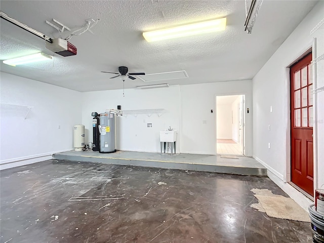 garage featuring electric water heater, sink, ceiling fan, and a garage door opener