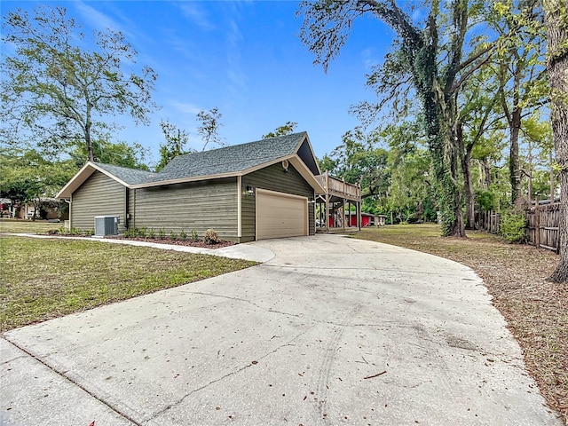 view of home's exterior with a garage, cooling unit, and a lawn