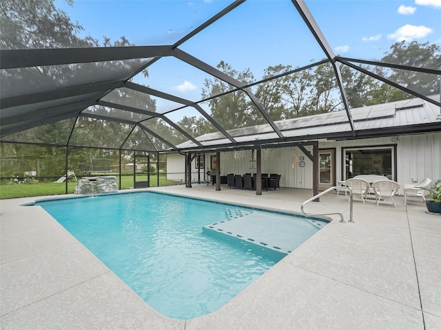 view of swimming pool featuring pool water feature, glass enclosure, and a patio area