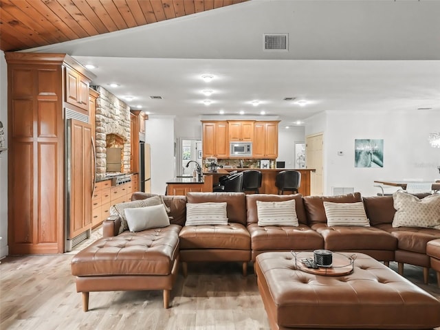 living room with light hardwood / wood-style floors, vaulted ceiling, wooden ceiling, and sink