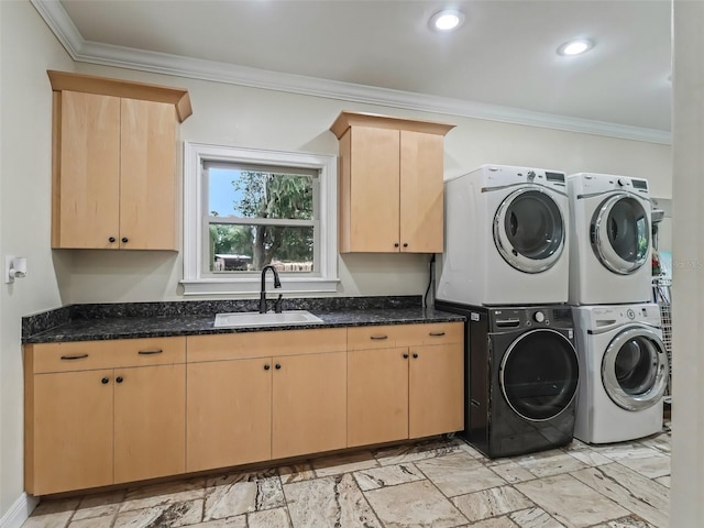 laundry area with washer and clothes dryer, crown molding, sink, and cabinets