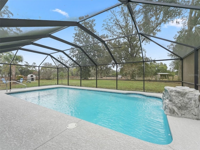 view of pool featuring pool water feature, glass enclosure, a patio area, and a lawn