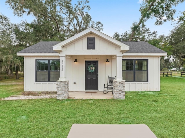 view of front of property featuring covered porch and a front lawn