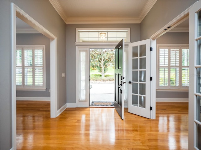 foyer entrance featuring french doors, light hardwood / wood-style floors, and crown molding