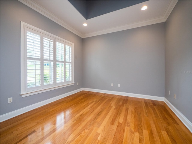 spare room with crown molding and light wood-type flooring