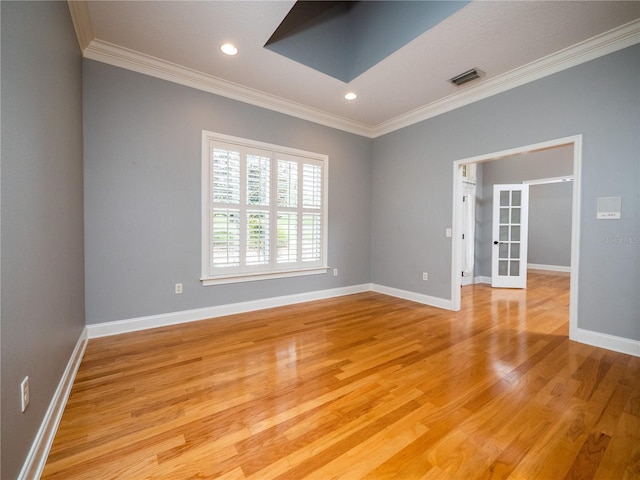 unfurnished room featuring crown molding, french doors, and light wood-type flooring