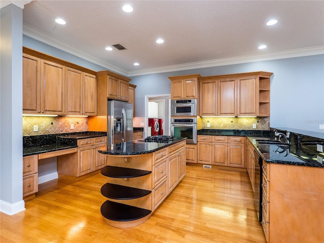 kitchen with a center island, dark stone countertops, light wood-type flooring, and stainless steel appliances