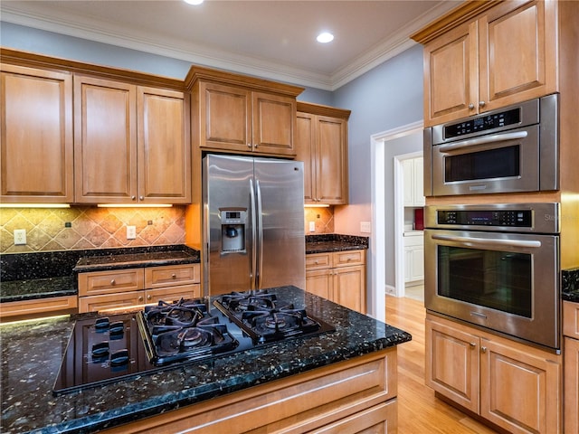 kitchen with stainless steel appliances, light hardwood / wood-style flooring, dark stone countertops, crown molding, and decorative backsplash