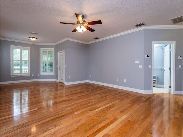 unfurnished room with ceiling fan, light wood-type flooring, a textured ceiling, and ornamental molding