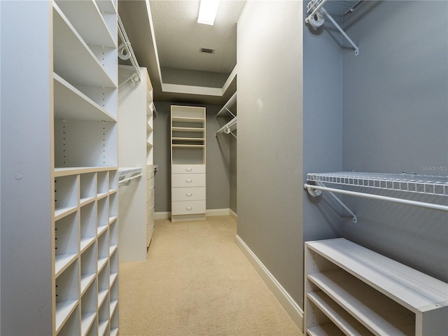 walk in closet featuring light carpet