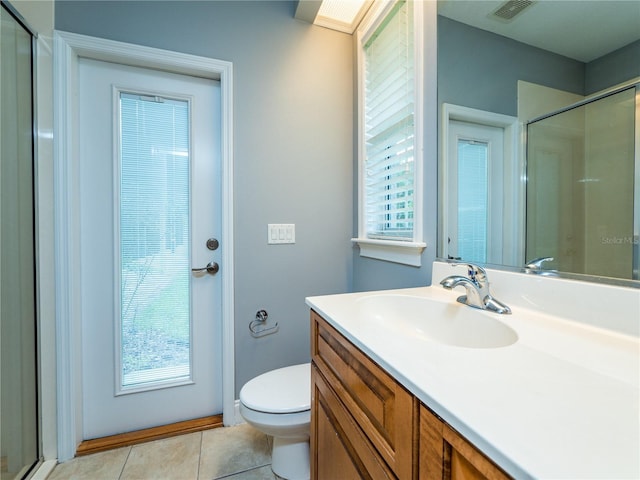 bathroom featuring toilet, tile patterned floors, walk in shower, and a healthy amount of sunlight