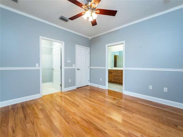 unfurnished bedroom with ceiling fan, light hardwood / wood-style flooring, ensuite bathroom, a textured ceiling, and ornamental molding