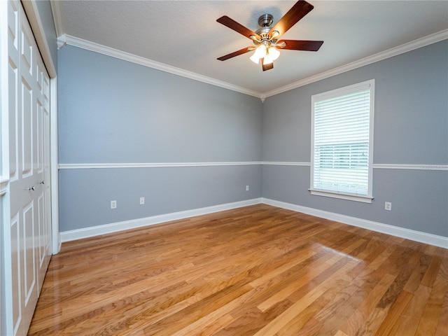 empty room featuring ceiling fan, crown molding, and light hardwood / wood-style flooring