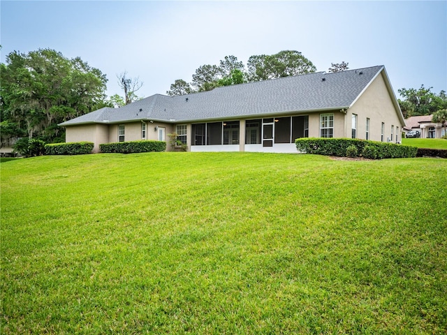 rear view of house with a sunroom and a yard