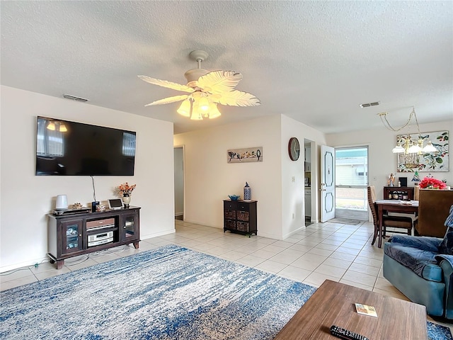 living room featuring a textured ceiling, ceiling fan, and light tile patterned flooring