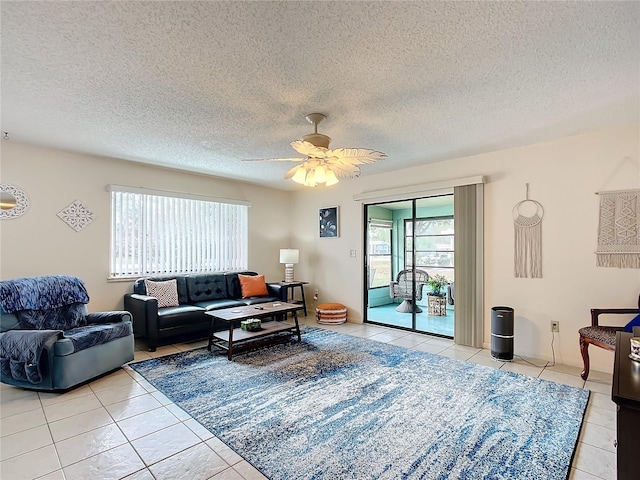 living room featuring light tile patterned floors, a textured ceiling, and ceiling fan