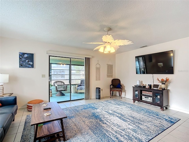 tiled living room with a textured ceiling and ceiling fan