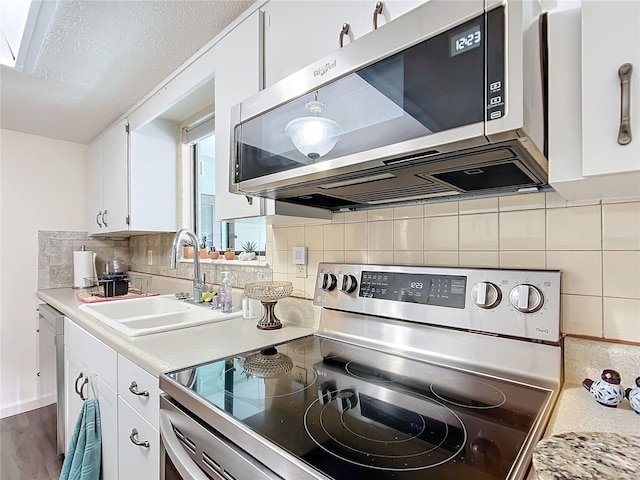 kitchen with white cabinets, sink, decorative backsplash, dark hardwood / wood-style flooring, and stainless steel appliances