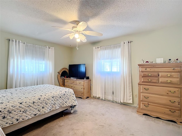 carpeted bedroom with ceiling fan and a textured ceiling