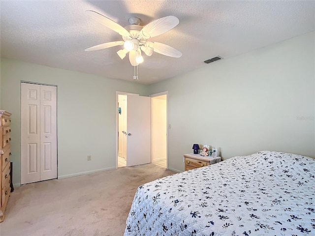 carpeted bedroom with a textured ceiling, a closet, and ceiling fan