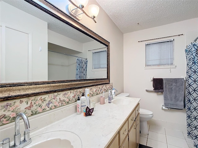 bathroom with vanity, tile patterned flooring, toilet, a textured ceiling, and curtained shower