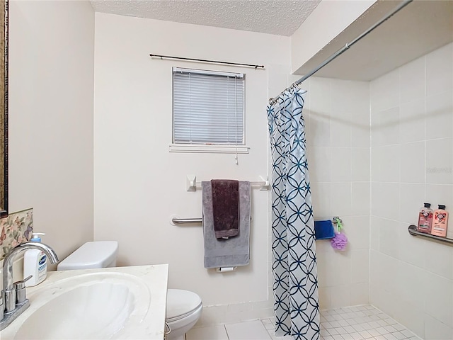 bathroom with a textured ceiling, sink, tile patterned flooring, toilet, and curtained shower