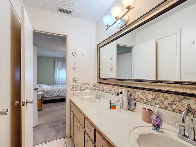 bathroom with vanity, a textured ceiling, and tile patterned flooring